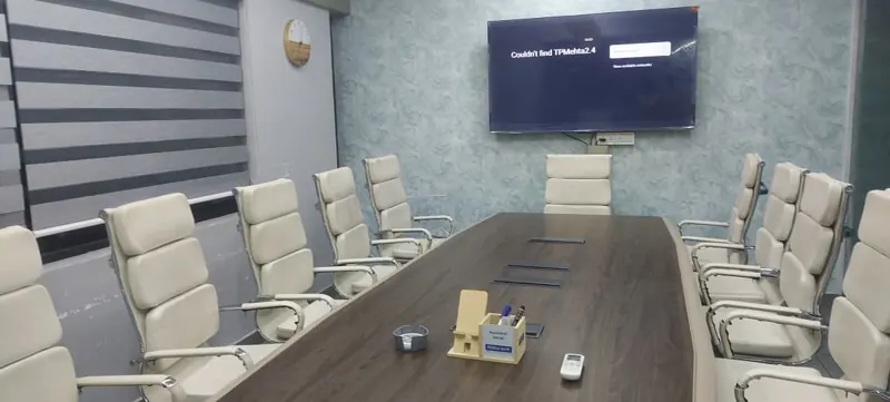 Conference room with a long table and wall display