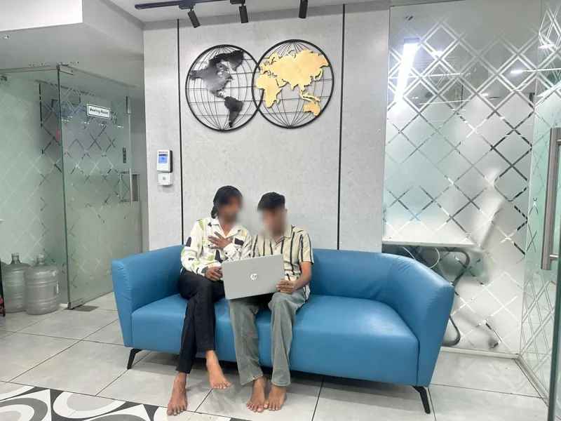 Reception lounge with blue sofa and world map wall art